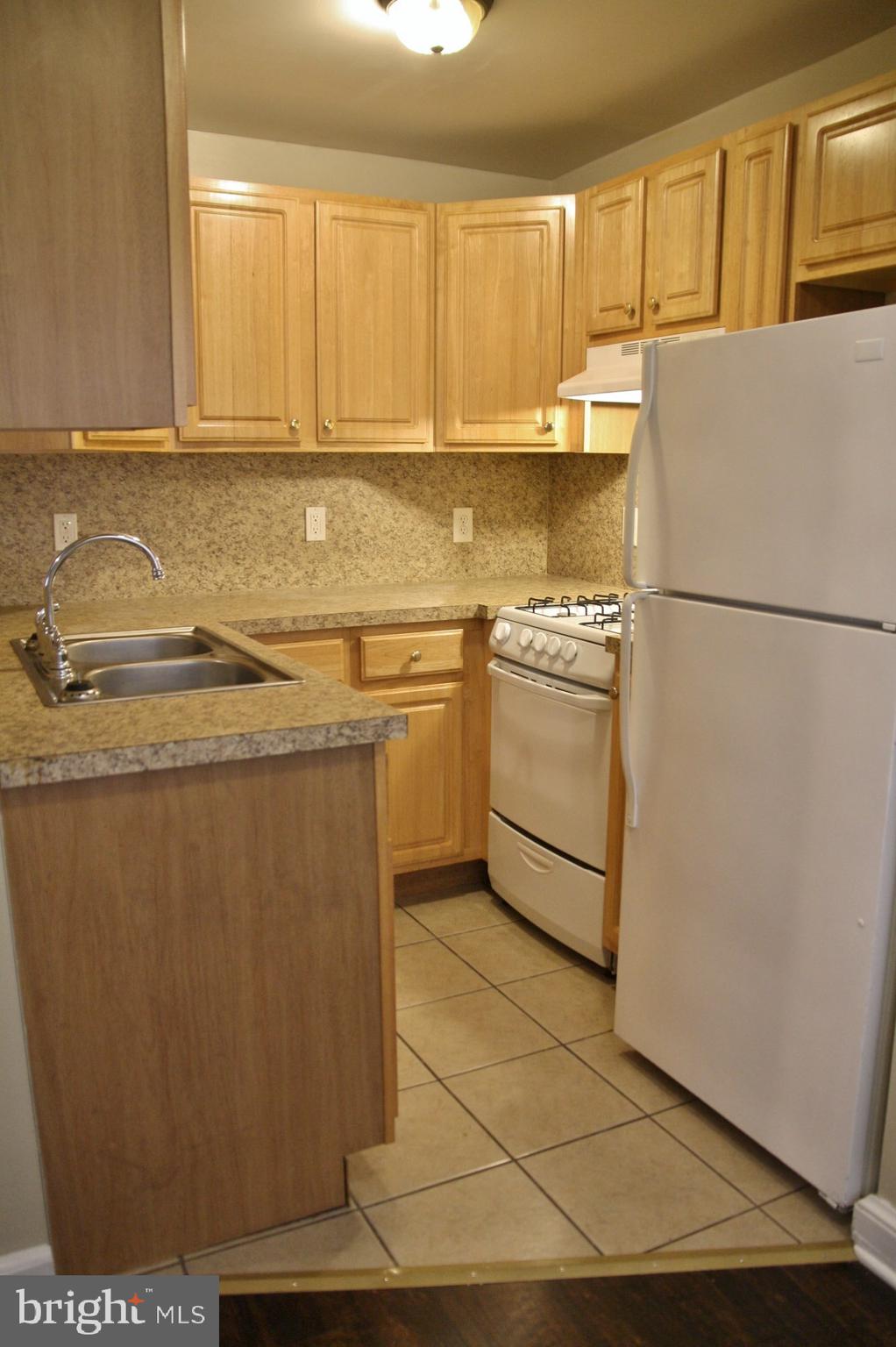 4004 Walnut Street, Unit A2 Harrisburg, PA 17109 - Photo 3 of 8 a kitchen with stainless steel appliances granite countertop a refrigerator a stove a sink and dishwasher