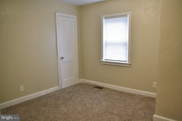 an empty room with windows and closet