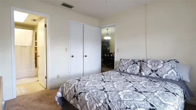 a bedroom with a large bed and a chandelier fan