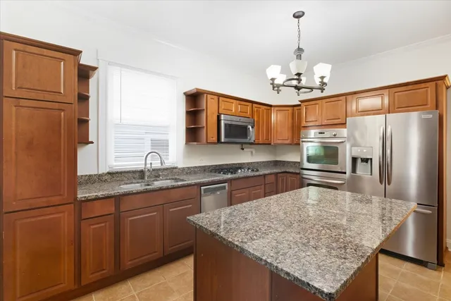 a kitchen with stainless steel appliances granite countertop a sink refrigerator and microwave