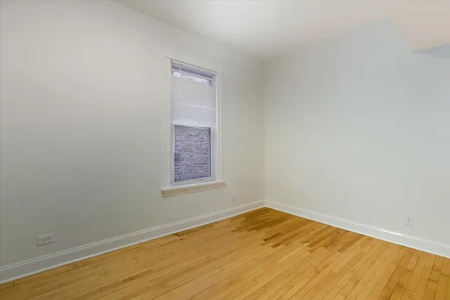 an empty room with a wooden floor and a window