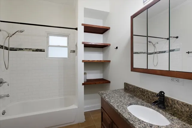 a bathroom with a granite countertop sink a mirror and shower