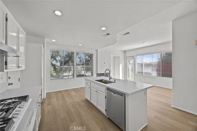 a kitchen with sink stove and wooden floor