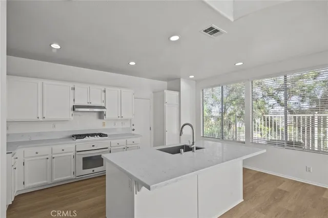 a kitchen with kitchen island a sink stove and cabinets