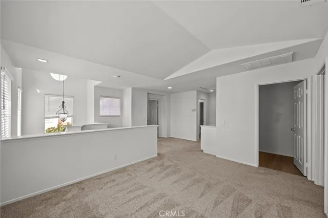 a large white kitchen with kitchen island a sink wooden floor and a refrigerator