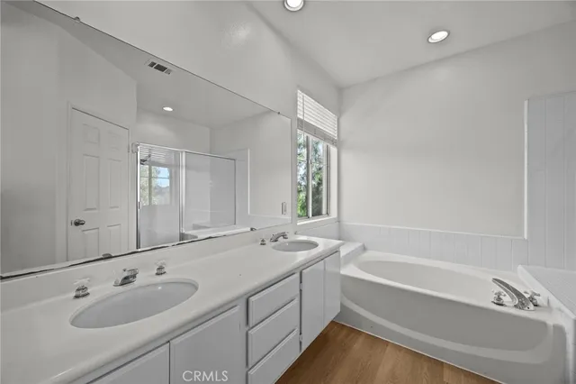 a bathroom with a tub double sink and mirror