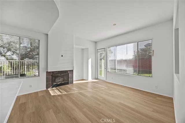 a view of empty room with wooden floor and fireplace