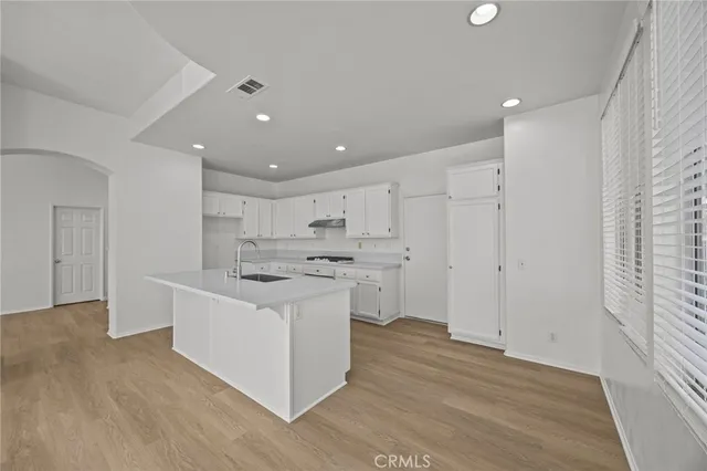 a kitchen with stainless steel appliances kitchen island hardwood floor sink and stove
