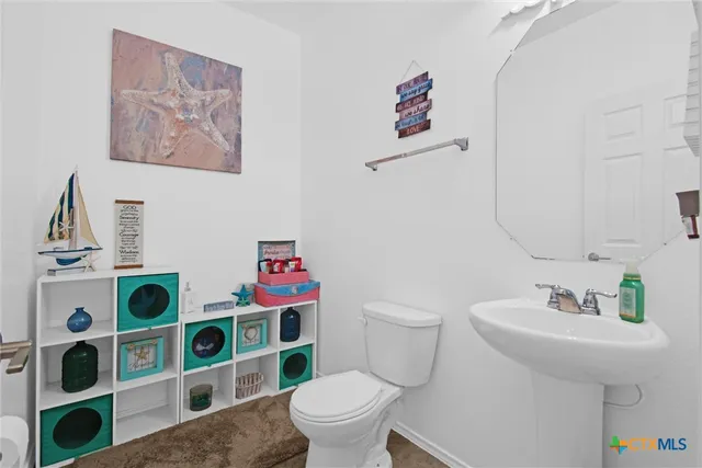 a bathroom with a sink mirror and toilet