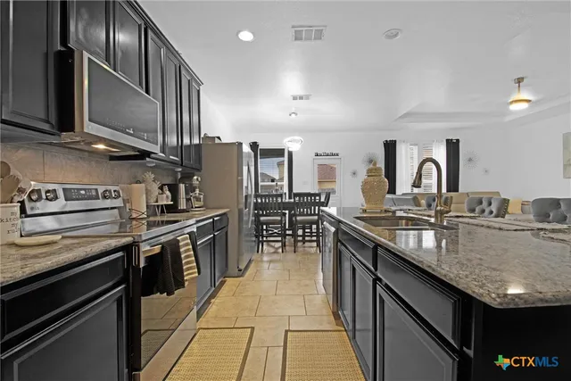 a kitchen with granite countertop stainless steel appliances and wooden cabinets