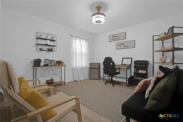 a view of a workspace with furniture and a window