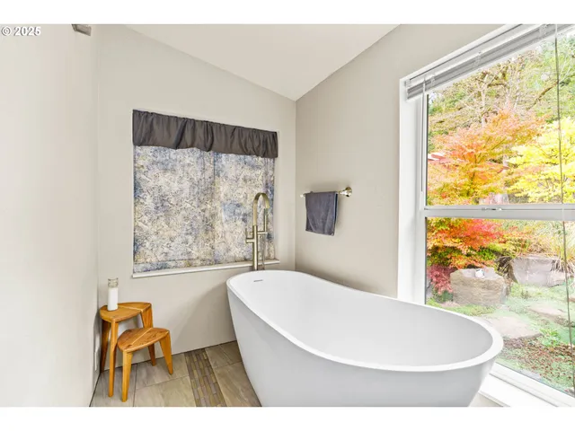 a white bath tub sitting in a bathroom next to a window