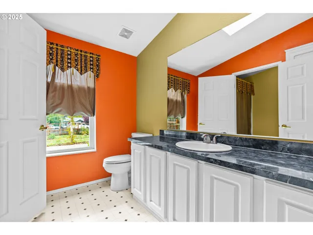 a bathroom with a sink a toilet and a mirror