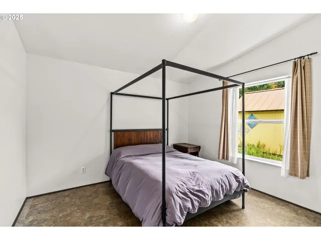 a bed sitting in a bedroom next to a window