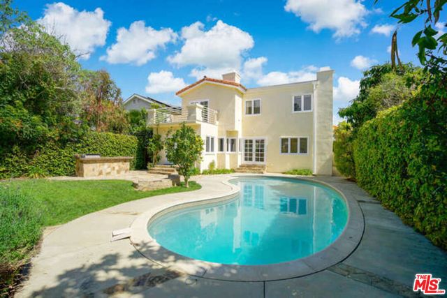 a view of a house with swimming pool and sitting area