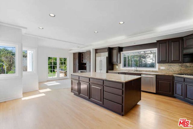 a kitchen with stainless steel appliances granite countertop a refrigerator and a sink
