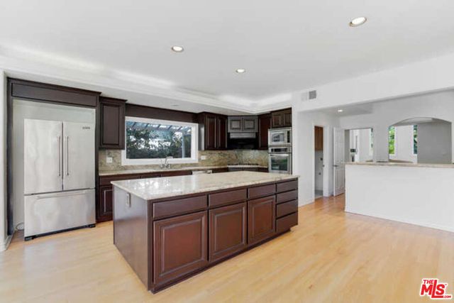 a kitchen with stainless steel appliances granite countertop a stove and a refrigerator