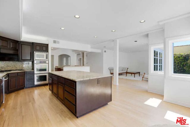 a kitchen with stainless steel appliances granite countertop a sink stove and cabinets