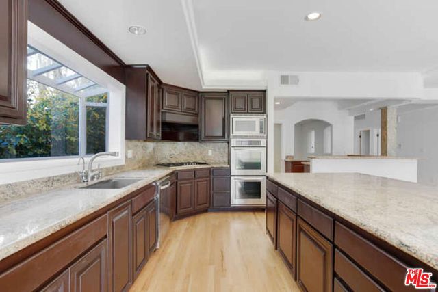 a view of a kitchen with a sink hardwood floor and a living room