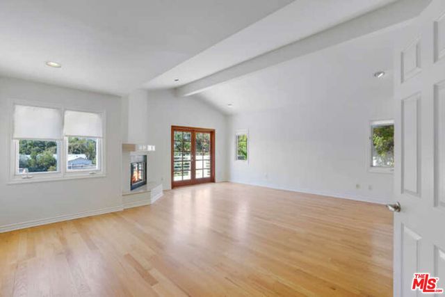 a view of an empty room with a fireplace and a window