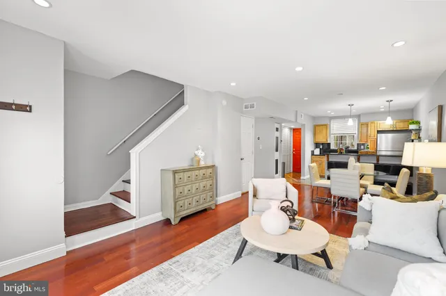 a living room with furniture and a wooden floor