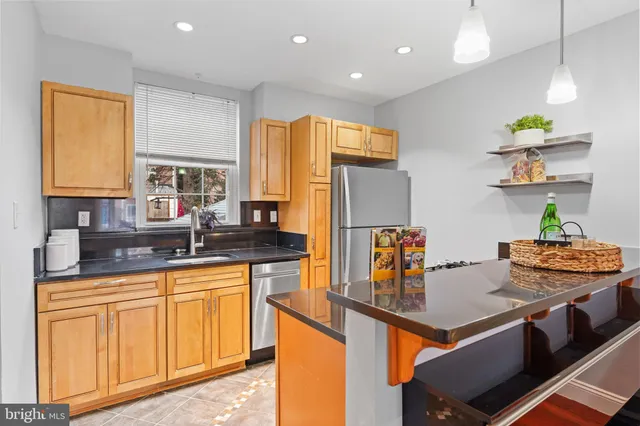 a kitchen with stainless steel appliances granite countertop a sink a stove and refrigerator