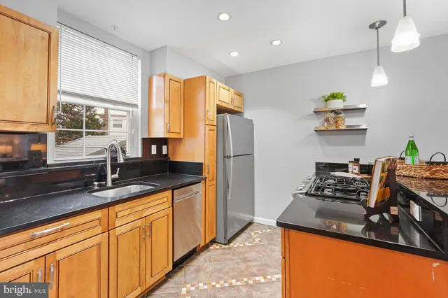 a kitchen with stainless steel appliances granite countertop a sink a stove and a refrigerator