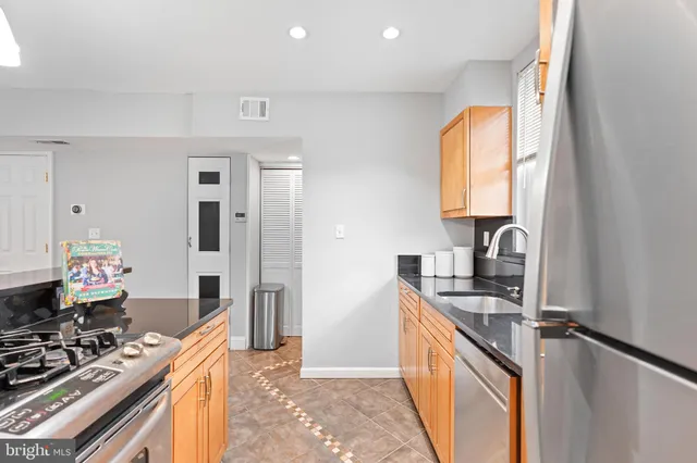 a kitchen with stainless steel appliances granite countertop a stove and a sink