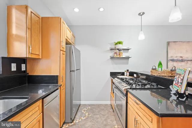 a kitchen with stainless steel appliances granite countertop a sink stove and refrigerator