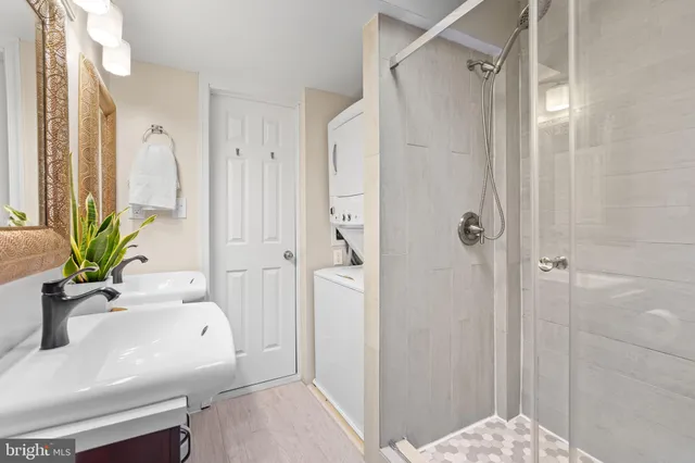 a bathroom with a sink a glass door shower and a mirror