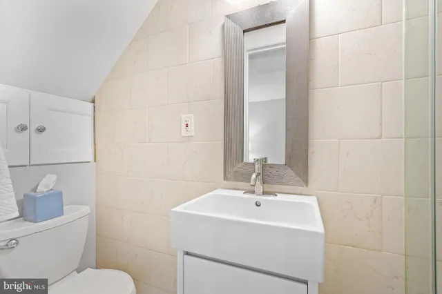 a bathroom with a sink toilet and a mirror