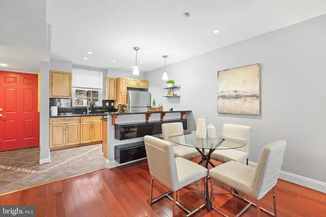 a kitchen with stainless steel appliances kitchen island granite countertop wooden floors and white cabinets