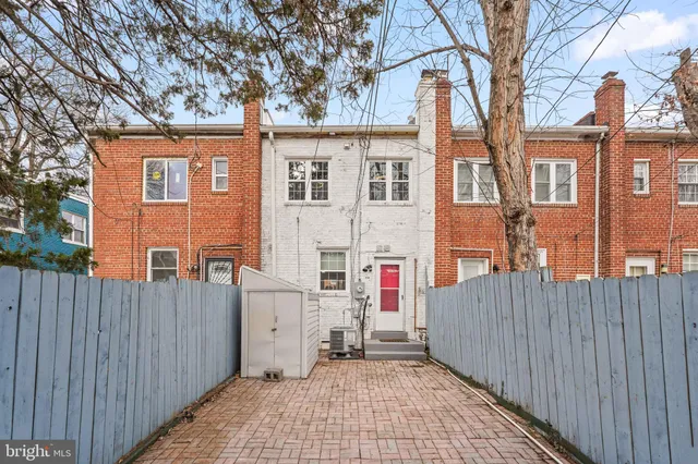 a view of a house with a small yard and wooden fence
