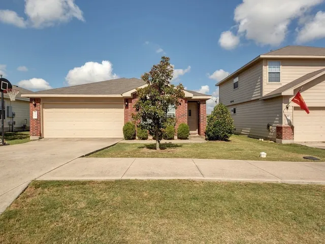 a view of a house with a yard and a garage