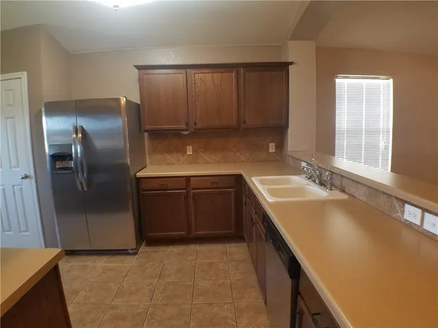 a kitchen with stainless steel appliances granite countertop a sink a stove and a refrigerator