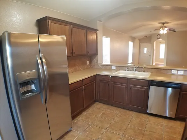 a kitchen with stainless steel appliances granite countertop a refrigerator and a sink