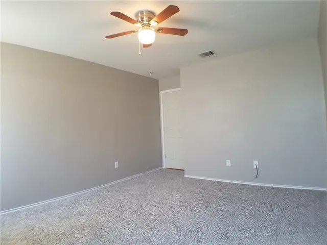an empty room with a window and a ceiling fan