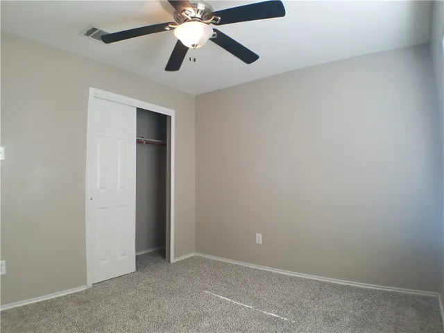 an empty room with a fan and a fan
