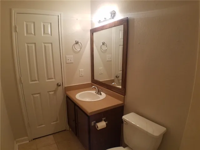 a bathroom with a toilet sink vanity and mirror