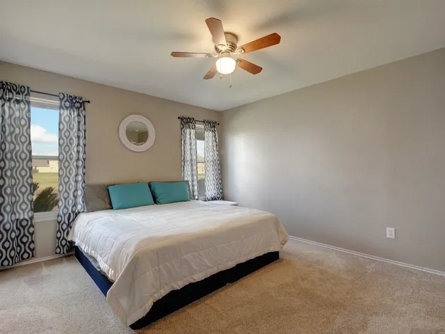 a bedroom with a bed and a ceiling fan