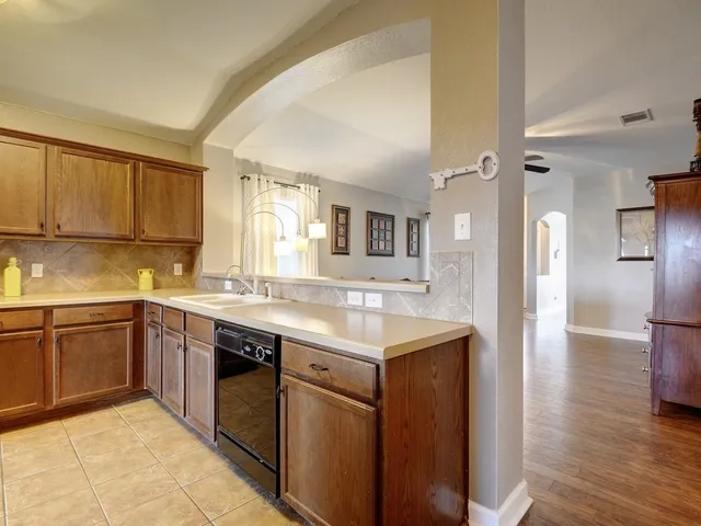 a kitchen with a sink cabinets and wooden floor