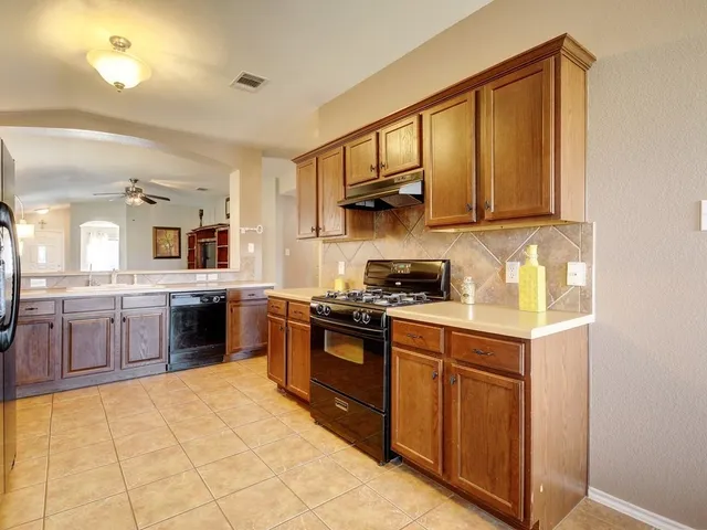 a kitchen with stainless steel appliances granite countertop a stove a sink and a refrigerator