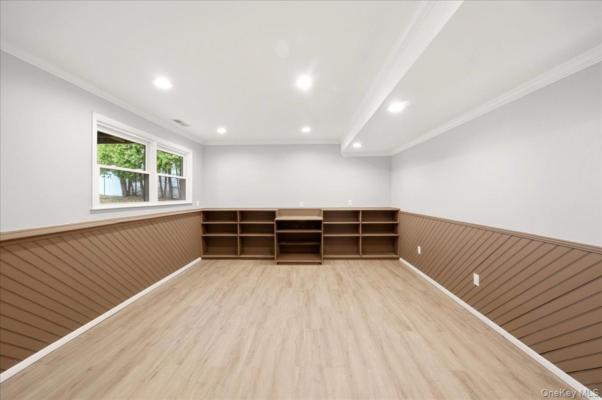 7 Gene Road Middletown, NY 10941 - Photo 25 of 43 Spare room with a wainscoted wall, ornamental molding, light wood-type flooring, and wood walls