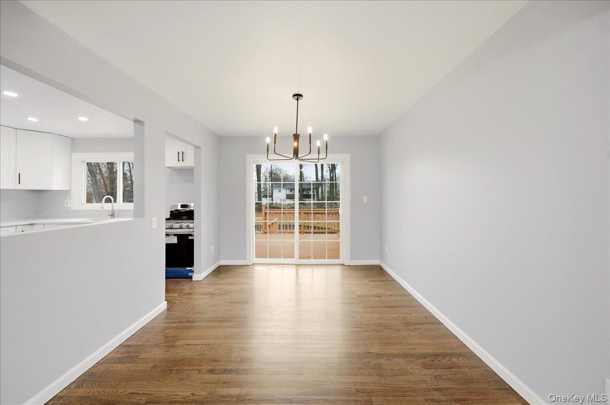 7 Gene Road Middletown, NY 10941 - Photo 10 of 43 Unfurnished dining area with dark wood-style flooring and a chandelier