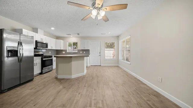 a kitchen with stainless steel appliances granite countertop a refrigerator a stove top oven a sink and dishwasher