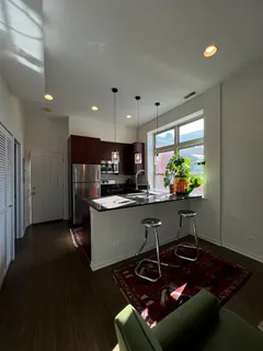 a kitchen with stainless steel appliances granite countertop a refrigerator and a dining table