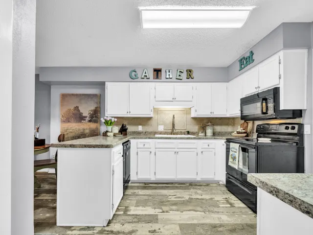 a kitchen with stainless steel appliances granite countertop a stove top oven a sink a counter space and cabinets