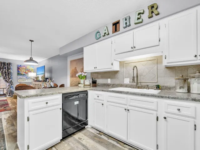 a kitchen with granite countertop cabinets stainless steel appliances and a sink