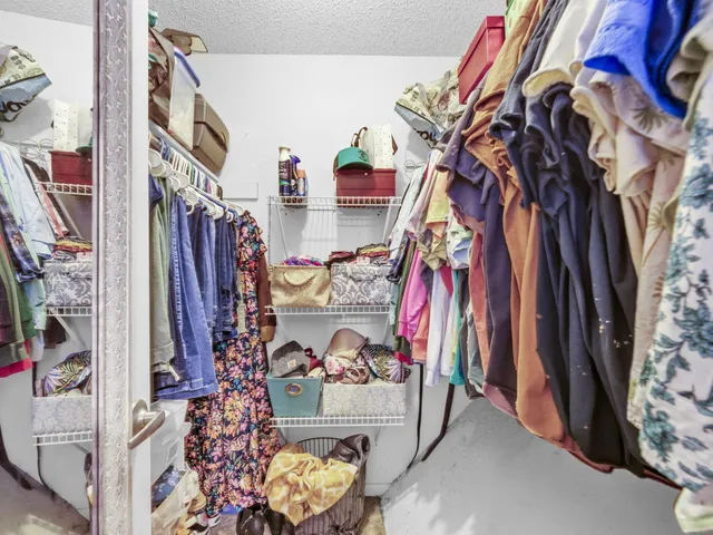 a view of walk in closet with clothes and shoes