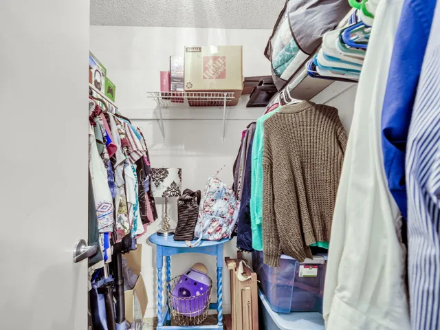a view of walk in closet with clothes and shoes